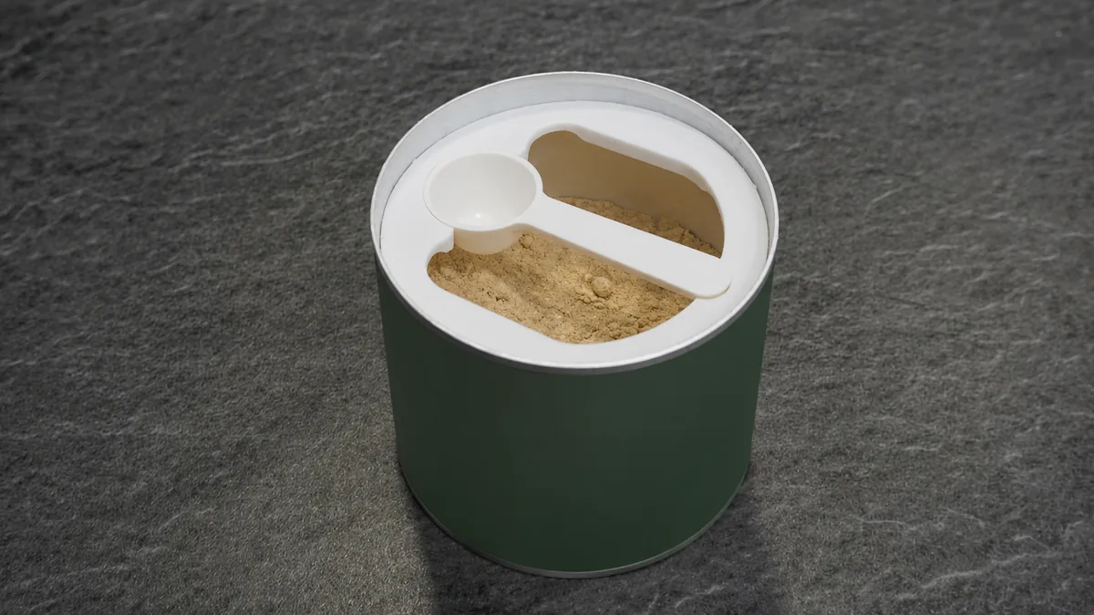 Einlegering mit 2,5-ml-Löffel auf einer Dose mit Pulver