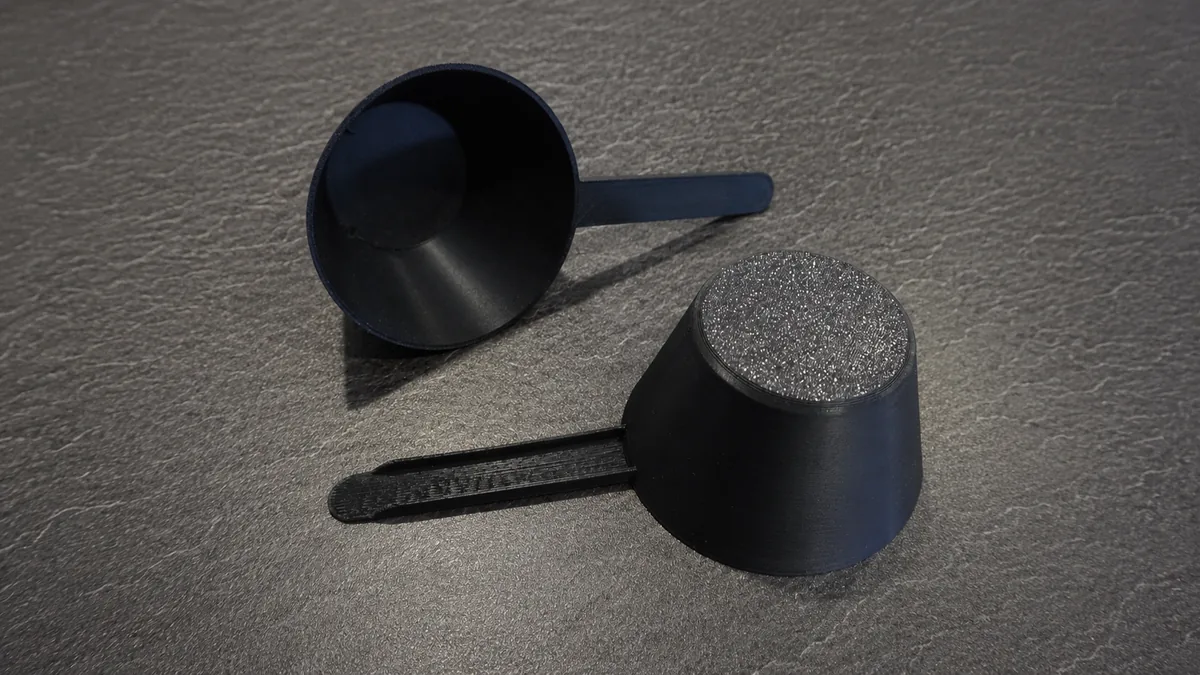 Zwei schwarze Messlöffel mit 40 ml Füllvolumen